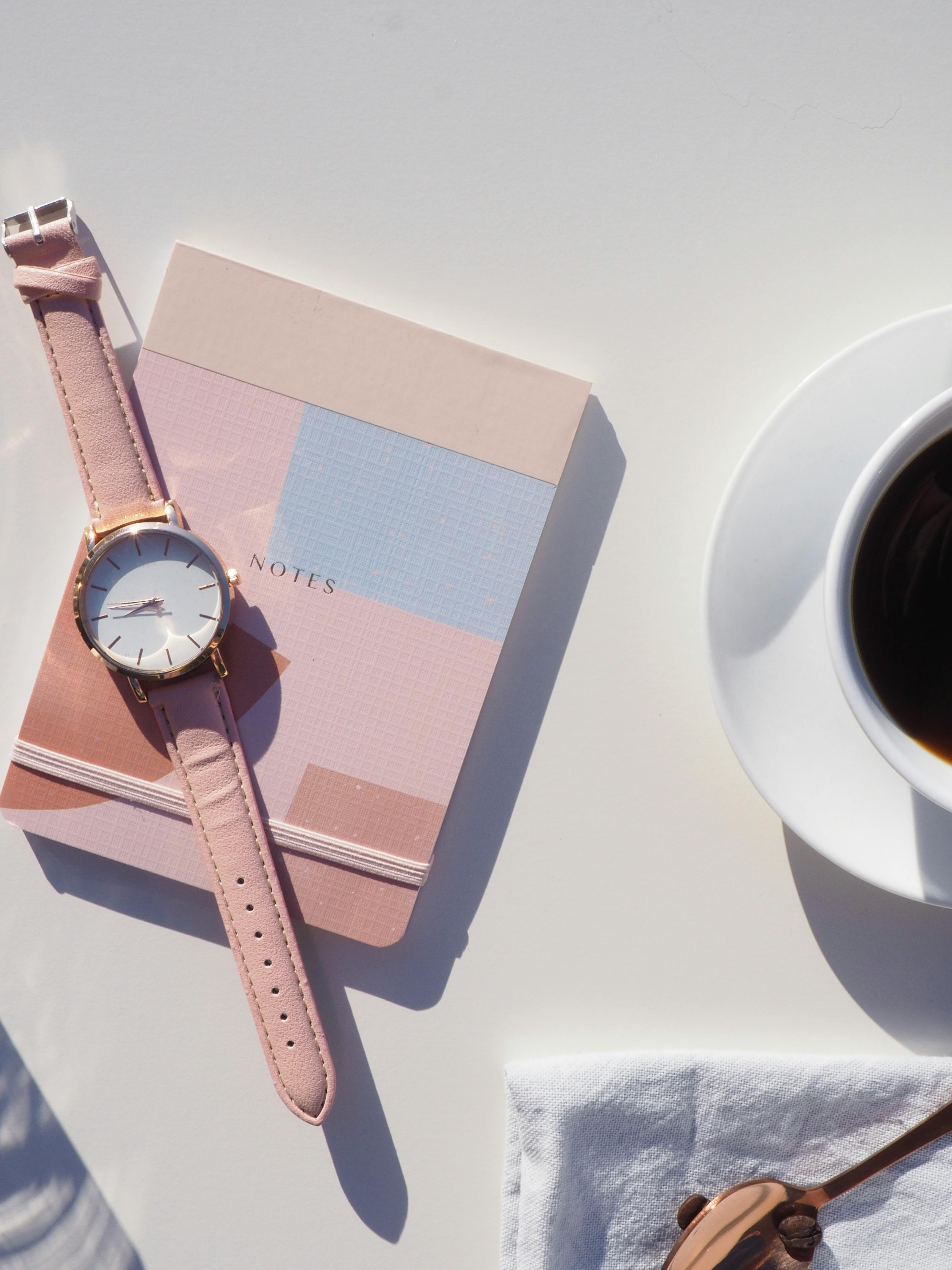 Elegant flat lay with wristwatch, notebook, and coffee, perfect for modern lifestyle themes.